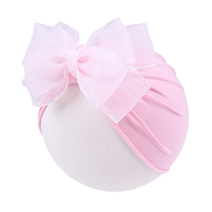 Detail of baby sun hat with pink organza bow and silver glitter edging on soft knit fabric