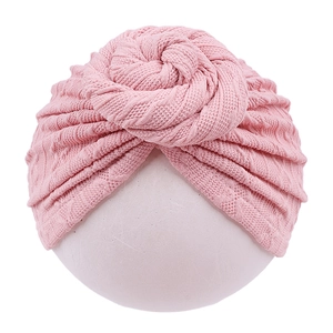Detail of baby donut knot turban hat in soft pink knit with ripple texture on white background