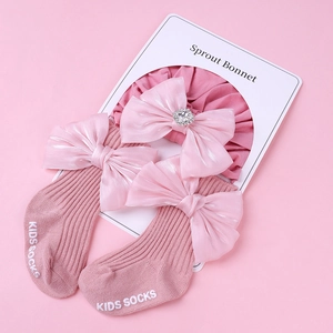Détail du turban rose pour bébé avec nœud en strass et chaussettes en coton assorties