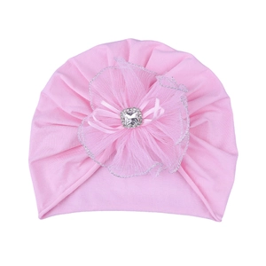 Close-up of pink baby turban hat with large mesh flower, rhinestone and silk ribbon detail