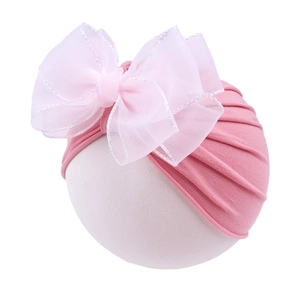 Detail of baby girl turban hat featuring a large double mesh bow with sequin edges