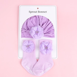 Détail d'un ensemble bonnet et chaussettes violets pour bébé avec fleurs et perles