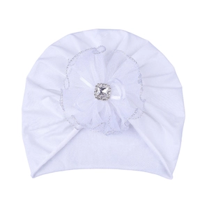 Detail of white newborn turban hat with layered lace flower and crystal decoration