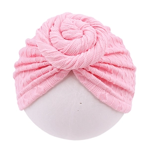 Close-up of pink baby turban hat showing 3D knit texture and spiral knot detail