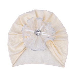Detail of baby turban hat featuring lace flower, ribbon bow and silver rhinestone
