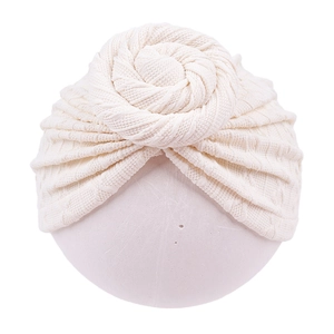 Detail of baby turban hat showing cream knit texture and large hand-sewn flower knot