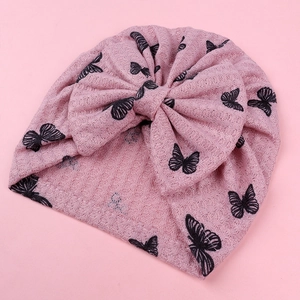Detail of baby turban hat featuring pink waffle knit fabric and large bow ornament