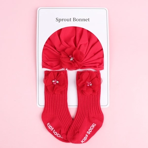 Détail de l'ensemble bandeau bébé rouge à fleurs et chaussettes assorties avec perles