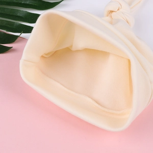 Detail of soft cream cotton baby knot hat showing high-quality inner seams and texture