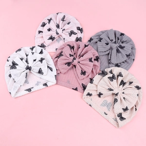 Detail view of five baby turban hats featuring waffle texture and black butterfly prints