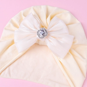 Détail du turban bébé avec grand nœud en tulle et centre en strass diamant brillant
