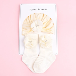 Détail de l'ensemble bandeau et chaussettes bébé crème avec fleurs 3D et perles