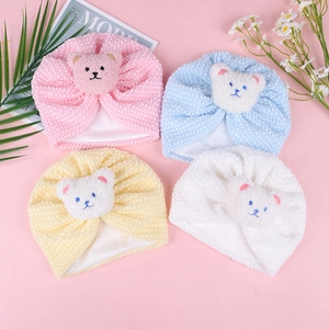 Close-up of baby waffle texture beanies with cute plush bear patches in four colors