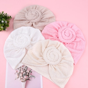 Set of four knitted baby turbans with spiral flower knot in beige pink and white shades