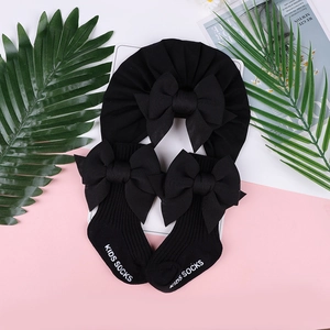 Dettaglio del turbante nero neonata e calzini con fiocco coordinati con scritta Kids Socks