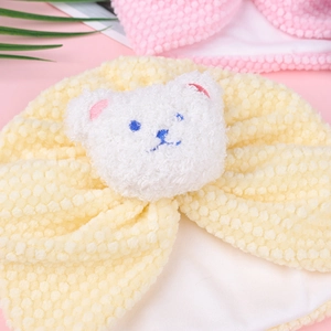 Detailed close-up of yellow baby bonnet with soft bubble texture and white plush bear patch