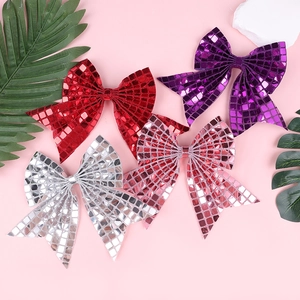 Close-up of glittery checkered bow hair clips in red, purple, silver, and pink party colors