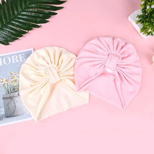 Detail of pink and cream infant turbans with soft pleats and high elasticity fabric