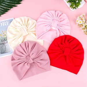 Detail of soft knit baby turban hats with center knot pleats in four colors