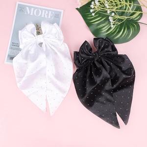 Détail de nœuds à cheveux en satin noir et blanc avec strass brillants et longs rubans