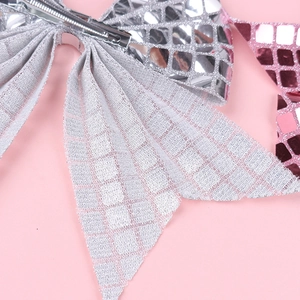 Close-up of a pink and silver mosaic glitter bow hairclip with a metal spring fastener