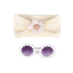 Détail d'un bandeau en nylon pour bébé et de lunettes de soleil rondes ornées de marguerites