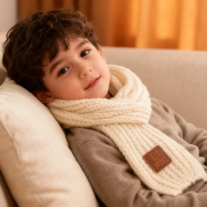 Detail shot of white knitted scarf texture with EST MOVE brown leather patch label