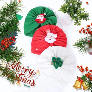 Three Christmas baby knot hats in red, green and white with festive plush decorations