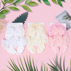 Detailansicht der Baby-Turban-Hüte und Socken mit eleganten Spitzen-Schleifen in drei Farben