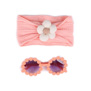 Vue détaillée du bandeau rose pour bébé avec fleur en tissu et lunettes marguerite
