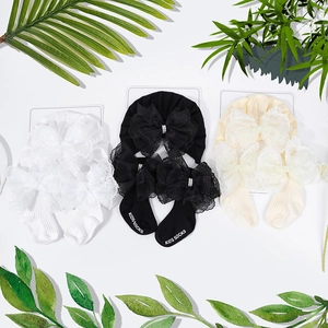 Detailsicht auf Kinder-Baumwollsocken mit großen Spitzenschleifen und Perlenblüten