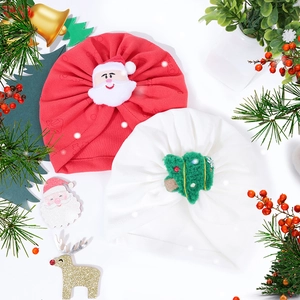 Detail of baby Christmas turban hats featuring plush Santa and festive tree designs