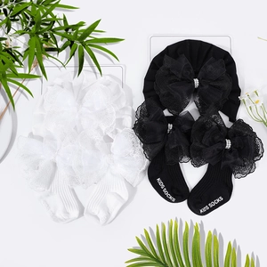 Detailansicht von Baby-Stirnband und Socken-Set mit großen Spitzenschleifen und Perlen