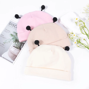 Détail de bonnets en maille douce pour bébé en rose et beige avec des antennes mignonnes