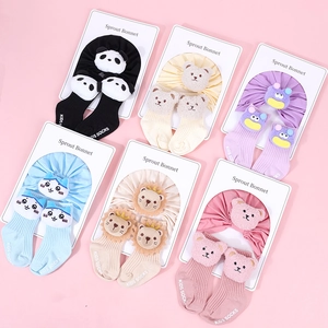 Detailed flat lay of cotton baby hat and sock sets featuring diverse 3D cartoon animal designs