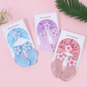 Detailansicht von Baby-Turbanmütze und Socken-Set mit Pailletten-Blumen und Rippstrick