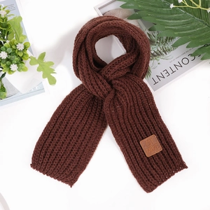 Close-up of dark brown knit scarf with vertical rib texture and leather logo patch