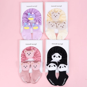Detail of four sets of infant cotton hats and 3D cartoon plush bear socks in various colors
