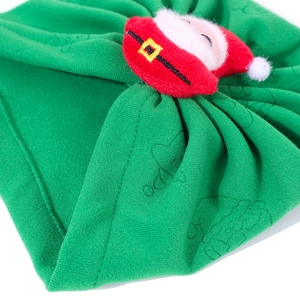 Close-up of green knit baby winter hat featuring a 3D plush Santa Claus holiday character
