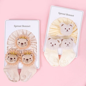 Detail view of cotton baby headband and socks set featuring plush lion and bear decorations