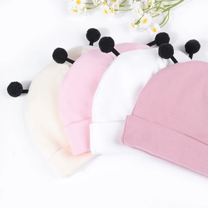 Lot de quatre bonnets en tricot pour bébé avec oreilles pompon noires en pastels