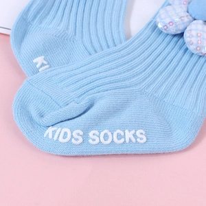 Detailansicht hellblauer Baby-Socken mit Paillettenblume und weißer Anti-Rutsch-Beschichtung