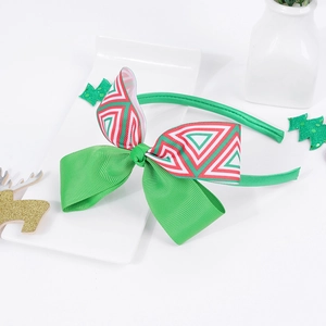 Dettaglio del cerchietto natalizio con grande fiocco verde e motivi geometrici festivi