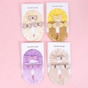 Detalle del conjunto de diadema y calcetines para bebé con lindos lazos pastel