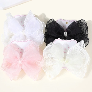 Detail of lace bow hair clips with pearls in white, black, pink and beige tones