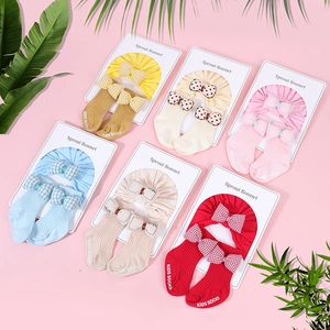 Detalle del set de diadema y calcetines para bebé en seis colores con lazo en el cartón