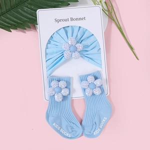 Detail von hellblauem Baumwoll-Set aus Mütze und Socken mit Paillettenblumen für Babys