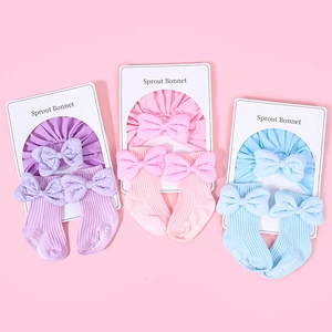 Detailed set of cotton baby bonnets and matching knee-high socks with large ribbon bows