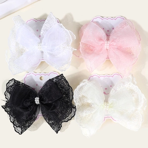 Detailed view of layered lace bow hair clips with pearls on cartoon display cards