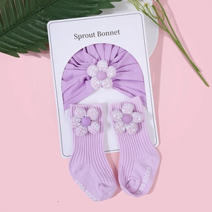 Detail von lavendelfarbenem Baby-Turban und Socken mit Pailletten-Blumendekor